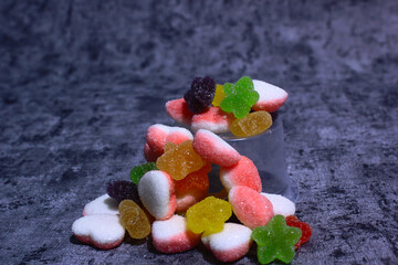 colorful candy with a variety of flavors in the photo with a cement-patterned background, the color...
