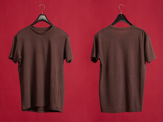 Exclusive hanger with empty brown t-shirt hanging isolated on a red background. Blank brown male...