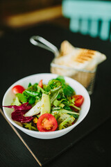 Bowl of juicy salad on a cafe table