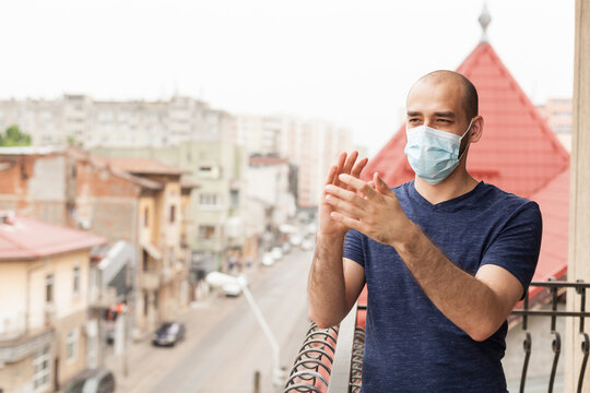 Adult Man With Protection Mask Clapping On Balcony Showing Support For Medical Staff On Fight With Coronavirus.