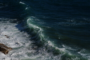 Ocean wave background breaking sea water rocky shore