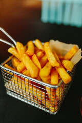 Basket of crispy French Fries on a cafe table