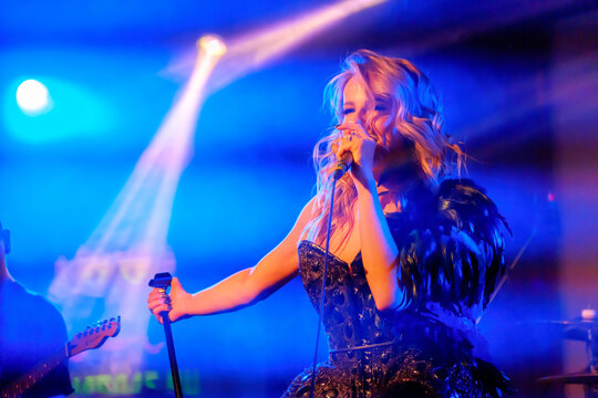 Girl Singer Sings On Stage Holding Microphone