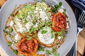 Avocado Toast featuring smashed avocado, grilled tomatoes, boiled egg on sourdough toast