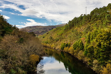 Fototapeta premium The sky reflecting on Lima river with green margins