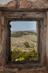 View to the forest inside a window of an abandoned house.