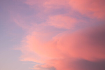 Fototapeta na wymiar puesta de sol con coloridas nubes de color rosa claro con cielo azul en el fondo