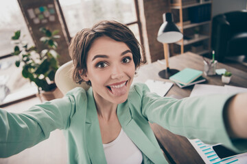 Positive cheerful playful girl blogger influencer secretary marketer agent make selfie show tongue...