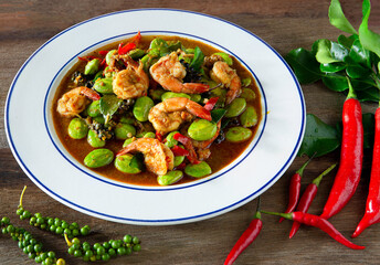 Stir fried Sato and shrimp with curry paste (thai food) in white dish put on old wooden table