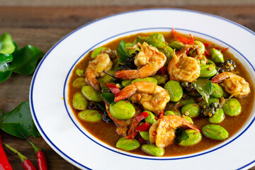 Stir fried Sato and shrimp with curry paste (thai food) in white dish put on old wooden table