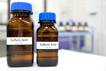 Strong sulfuric acid chemical in brown amber glass bottle inside a laboratory with copy space.