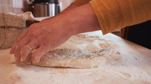 Woman hands stretch and fold the bread dough before further leavening - camera slide