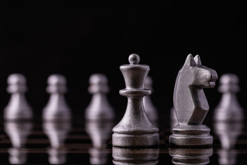 Chess pieces in silver on a black background. Board game chess.
