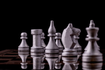 Chess pieces in silver on a black background. Board game chess.
