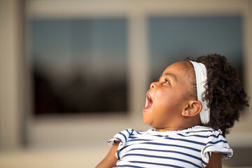 Happy little girl laughing and smiling outside.