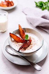 Milk Buckwheat Porridge with Caramelized Pears on grey concrete background. Healthy breakfast. Selective focus