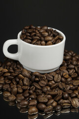 White mug with coffee grains sprinkled with coffee grains on a background