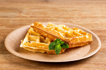 .Viennese waffles on a disposable plate with mint