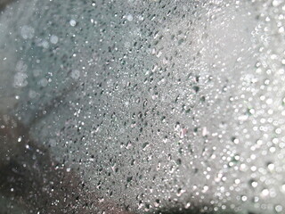 Background or texture of raindrops on a blurred car glass With reflection resulting from using flash For background work.
