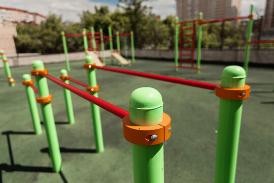 green and red horizontal bars on a playground in the summer
