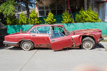 Fototapeta na wymiar old wreck broken car on the street