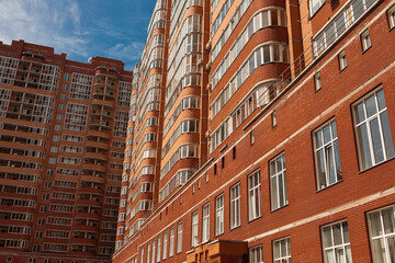 Fototapeta na wymiar brick building made of orange brick close-up and blue sky 