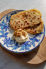 Homemade pita bread served with mayonnaise. Vegetarian starter dish served in a vintage blue plate. 
