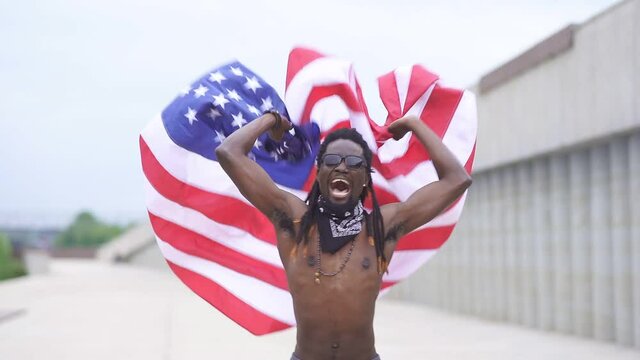 African American male protester waves an American flag in the street, Slow motion.