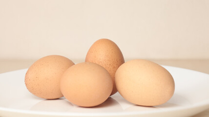 Four chicken egg on white dish and have a single egg straight