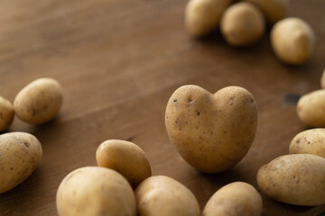 Kartoffel Herz auf braunem Holz Hintergrund