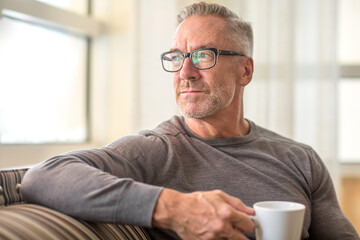 Mature man sitting on a sofa sock photo