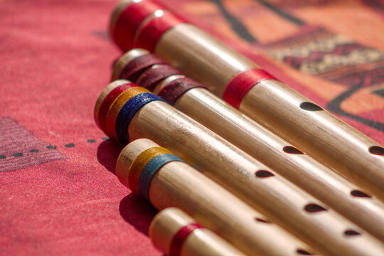 Hindu bamboo flute called Bansuri on a red table.