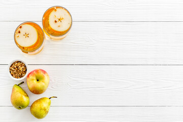 Glasses of beer with apple and peer on white wooden table top view copy space
