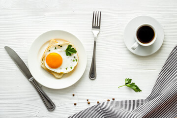 Fried eggs sandwich on plate - white dinner table top view