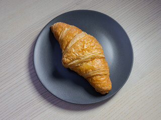 A plain croissant on a plate.