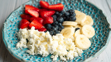 Healthy summer breakfast. Cottage cheese with strawberry blueberry banana and honey. Beautiful breakfast