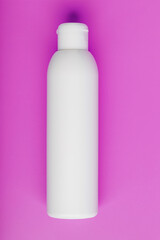 White bottle on pink background. Free space for text.