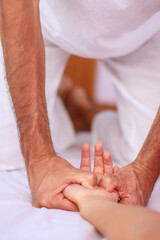 Obraz na płótnie Canvas Vertical view of Shiatsu massage supine position massaging palm stretching opening palms.