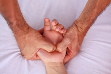 Shiatsu massage. Close up of massagers hands working on patients hand and lower shoulder.