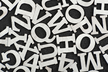 Black and white pattern of randomly placed letters of English alphabet. Close up