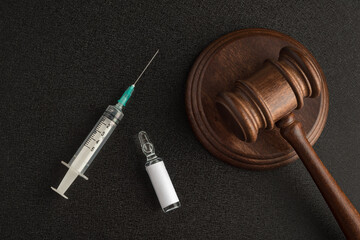 Syringe vial with an empty label and judges gavel or mallet law and. Laws and decisions against...