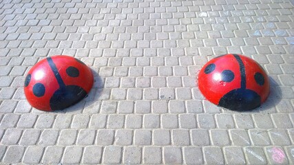 Sleeping policeman as concrete hemispheres like red ladybugs. Stop movement and parking car. Speed...