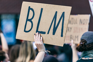 Woman's hand holding Black Lives Matter sign