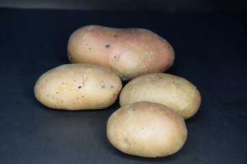 Selective focus of potatos on black background, Close up of potatoes on black, Vegetable concept, Cooking concept, Food and drink.