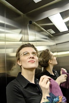 Portrait Woman, Businesswoman, In Office Dark Clothes, In A Dark And Cramped Space, Elevator.