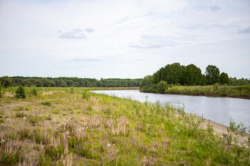 View of the Tara river, Omsk region, Siberia, Russia. Surroundings of the Siberian expanses. Picturesque view on the steep Bank of the river.