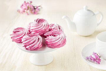 Pink meringue with flowers and white teapot