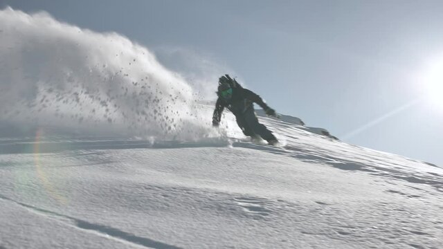 Snowboarder riding down the backcountry in Switzerland.