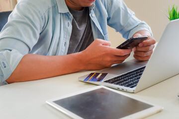 Hands holding credit card and using laptop. Online shopping