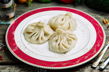 Restaurant dish of Georgian cuisine. Hot khinkali on a plate with pepper.